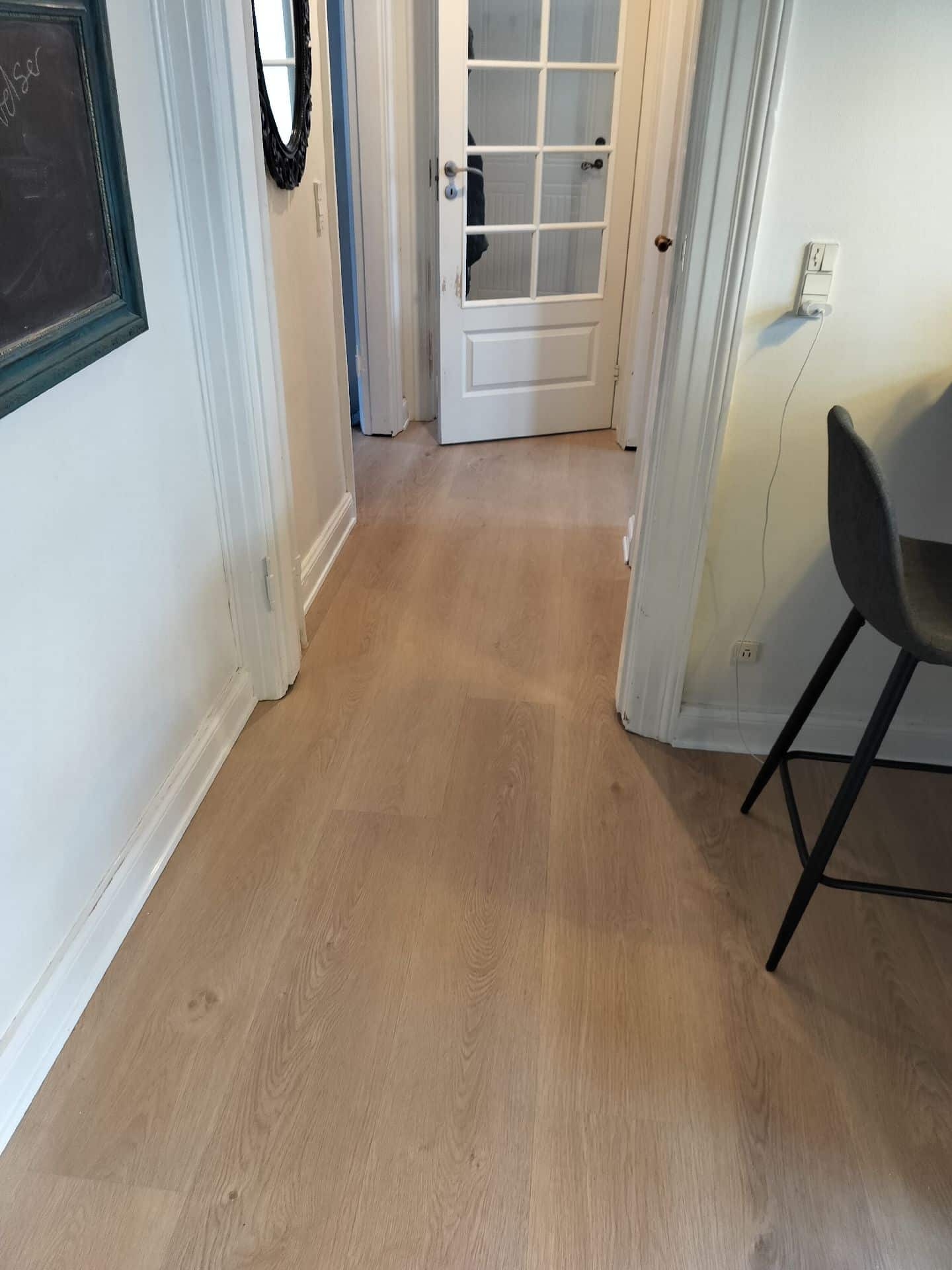 opretning af eksisterende gulve. montering og tilpasning af 12 mm. gulvplader. Nye gennemgående vinyl laminat gulve. Afsluttet med sandliste langs eksisterende fodpaneler.